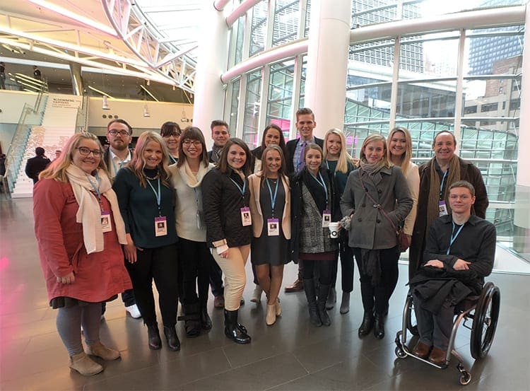 Students, led by Dr. Catherine Luther and Professor Stuart Brotman, pose for a group photo on the sixth floor of Bloomberg’s New York headquarters.