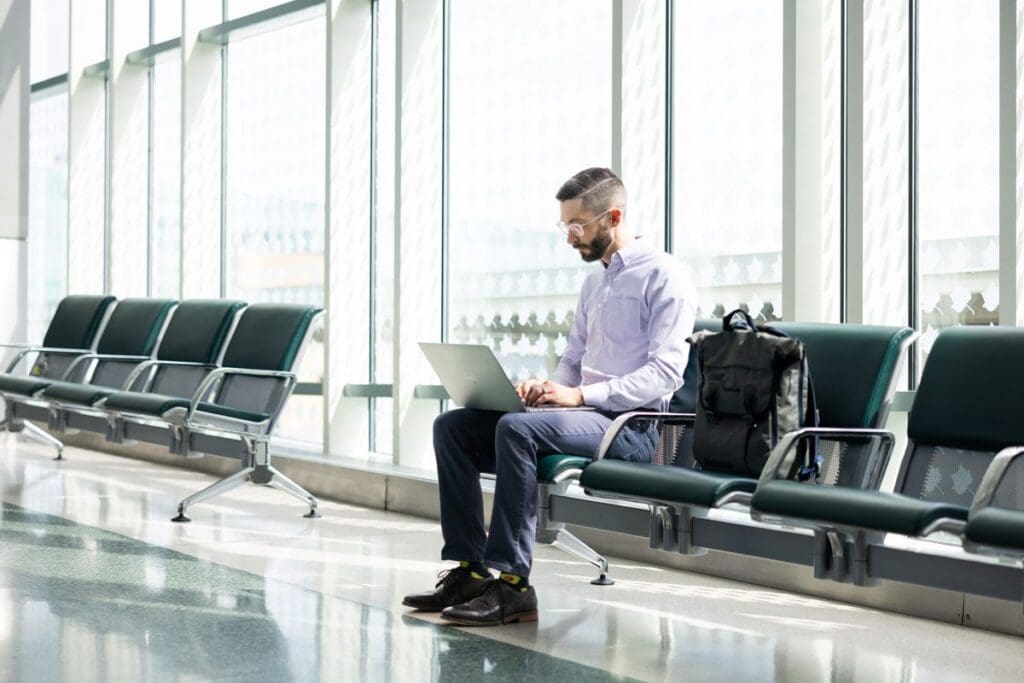 A student sits in a public space working on a laptop.