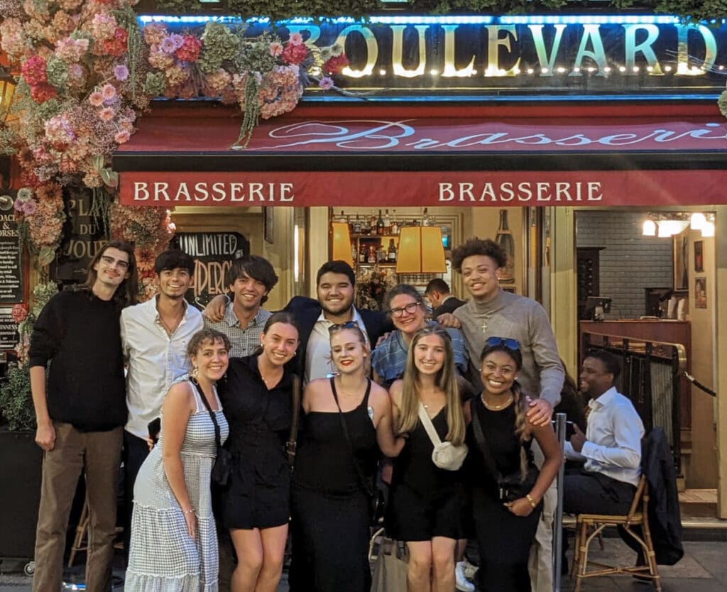 Students on the JEM UK sports trip pose in front of Boulevard Brasserie in London.